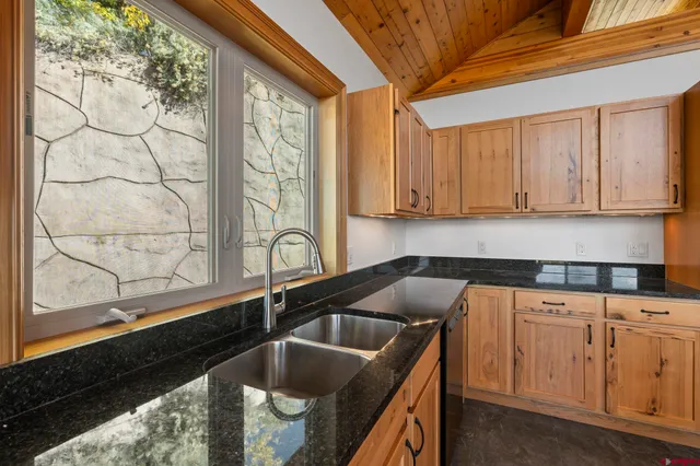 a kitchen with granite countertop a sink and cabinets