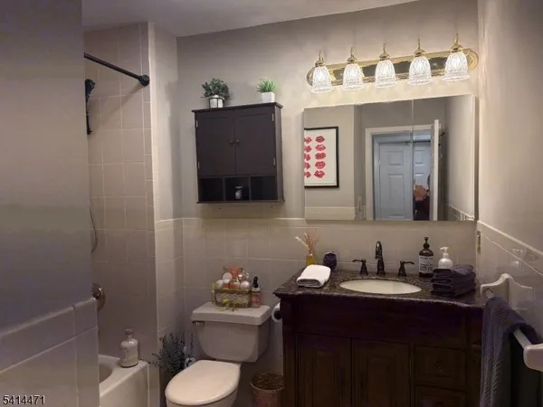 a bathroom with a granite countertop sink toilet and mirror