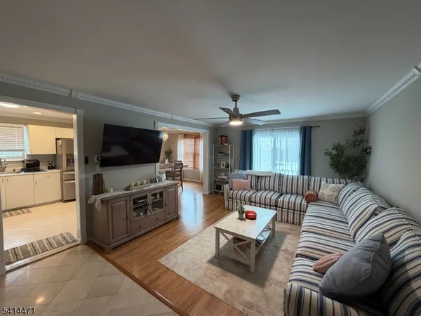 a living room with furniture kitchen view and a flat screen tv