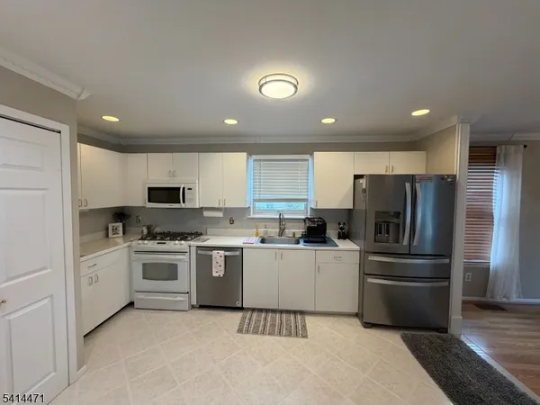 a kitchen with stainless steel appliances kitchen island granite countertop a stove sink and refrigerator