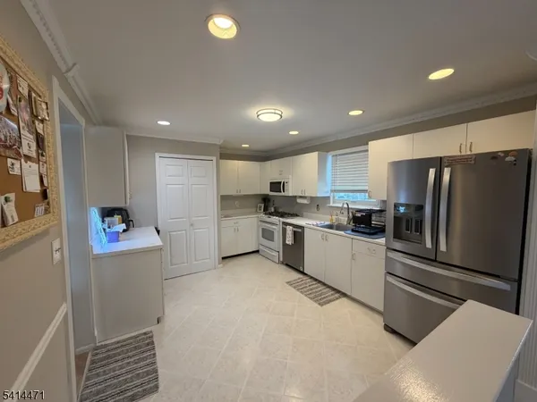 a kitchen with stainless steel appliances a refrigerator and a stove top oven