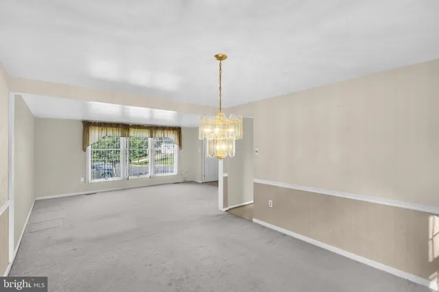 a view of a room with window wooden floor and front door