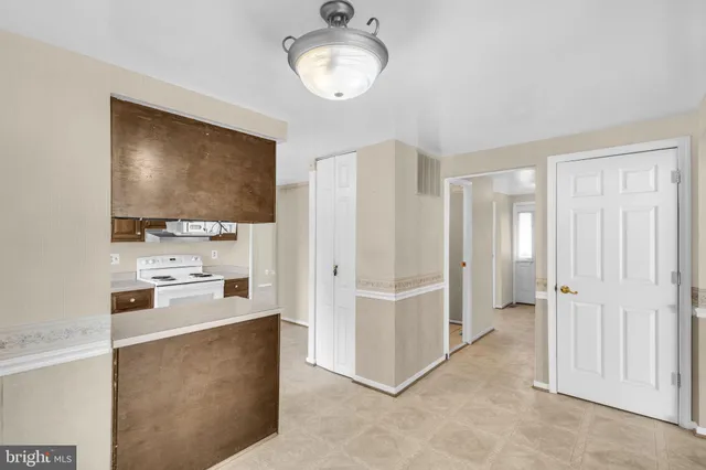 a view of a livingroom with wooden floor and kitchen space