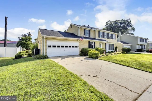 a front view of a house with a yard and trees