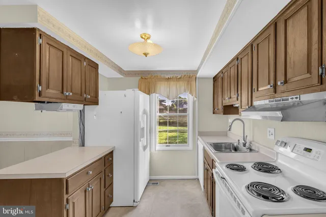 a kitchen with a white stove top oven and refrigerator