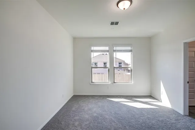 an empty room with windows and mirror