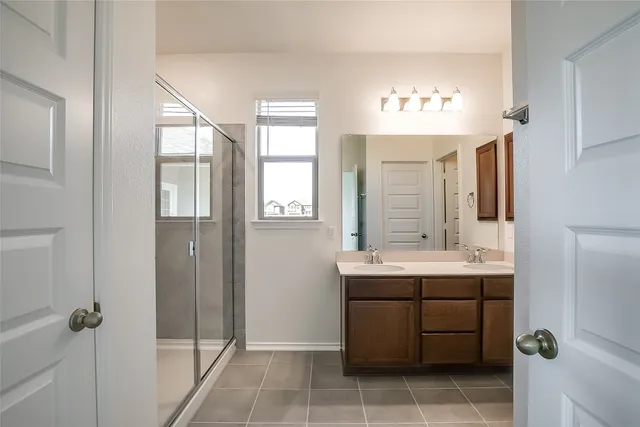 a bathroom with a double vanity sink a mirror and a bathtub