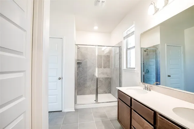 a bathroom with a shower sink and mirror