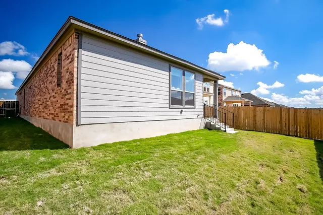 a view of a backyard with wooden fence