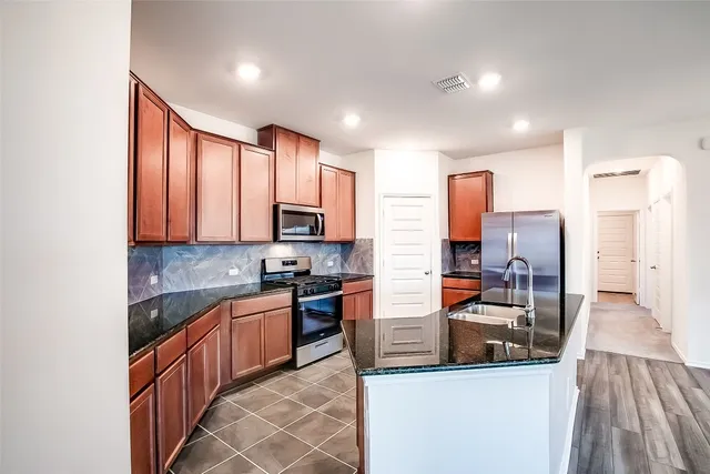 a kitchen with stainless steel appliances granite countertop a sink stove and refrigerator