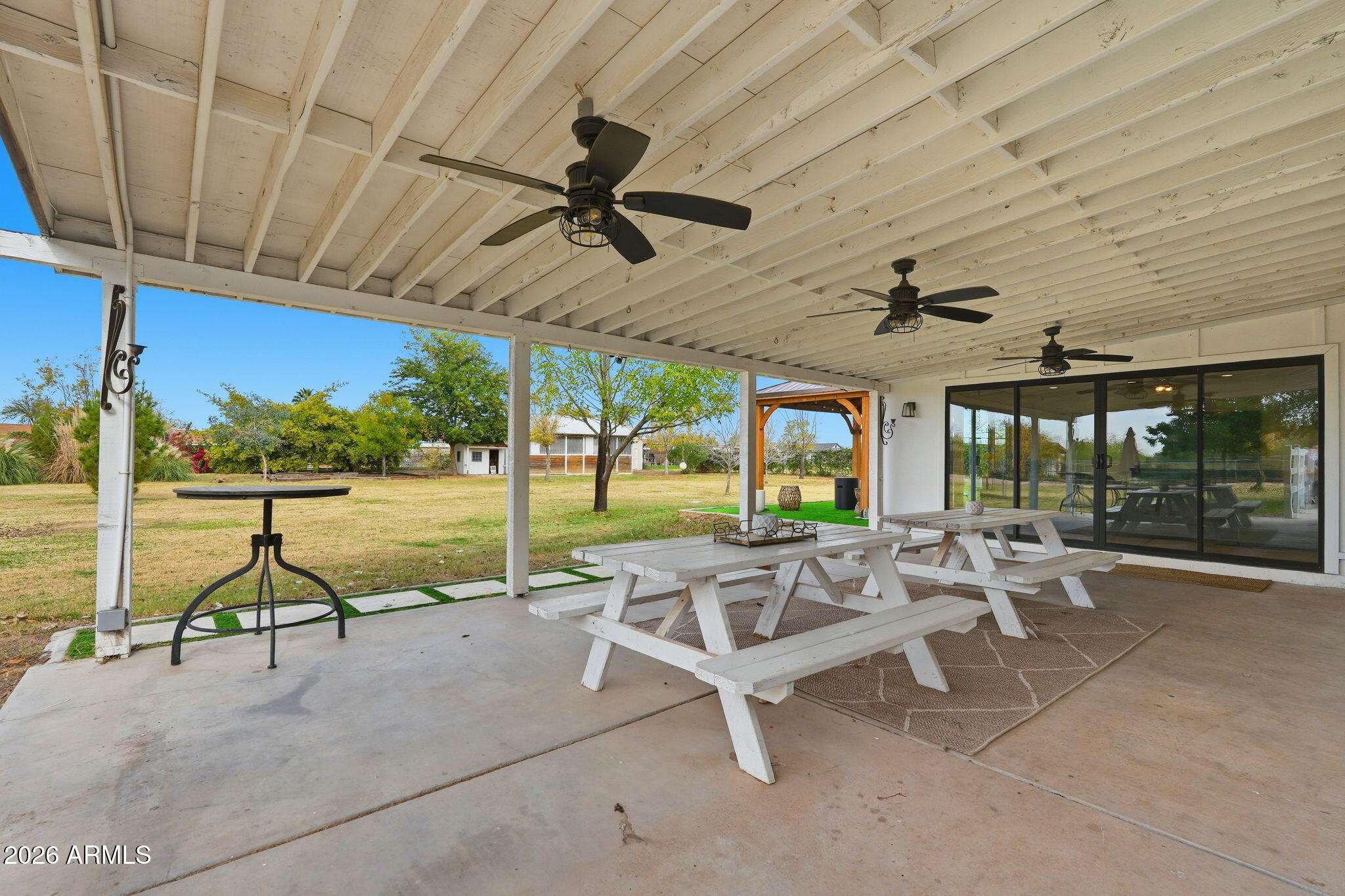 2858 East Redfield Road Gilbert, AZ 85234 - Photo 57 of 60 a view of a patio with a table chairs and a floor to ceiling window