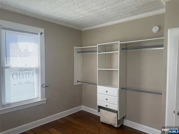 a room with a walk in closet and wooden floor