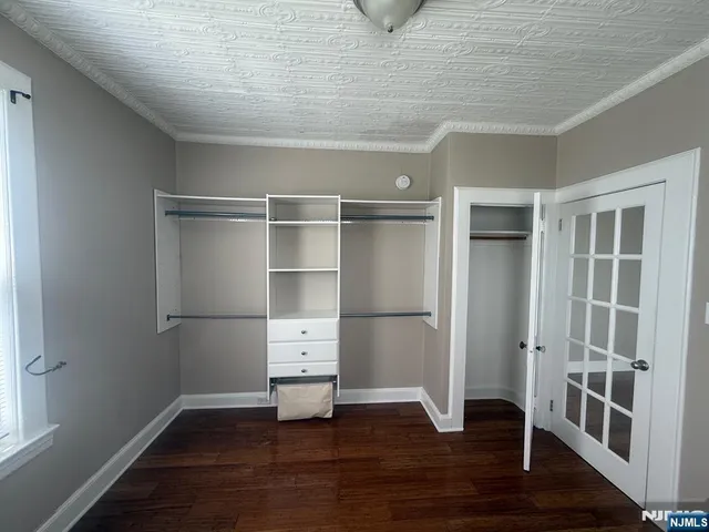 a view of empty room with wooden floor and cabinet
