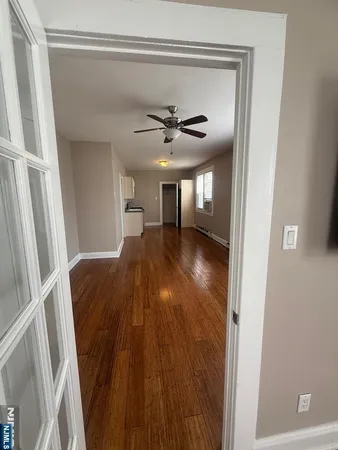 a view of a livingroom with a ceiling fan and wooden floor