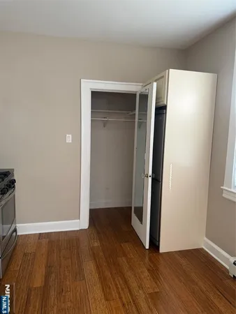 an empty room with wooden floor and closet