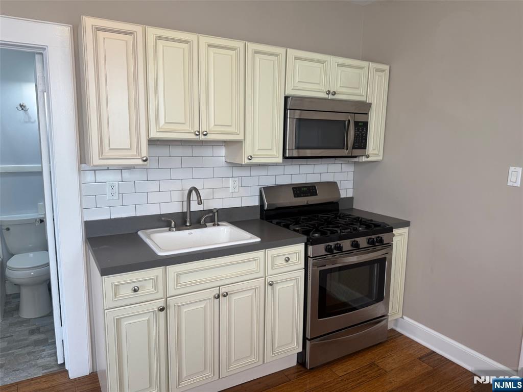 59 Union Avenue, Unit 3 North Arlington, NJ 07031 - Photo 4 of 15 a kitchen with stainless steel appliances granite countertop a sink stove and microwave