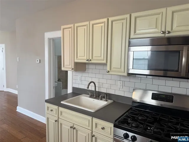 a kitchen with stainless steel appliances a stove a sink and a microwave