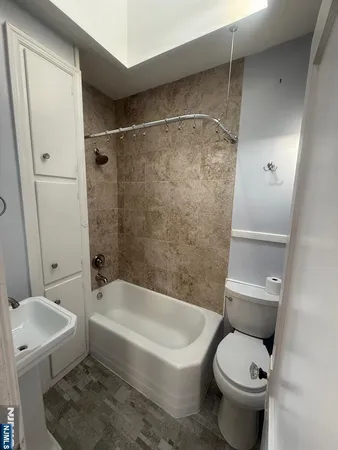 a white toilet sitting next to a bath tub and a shower