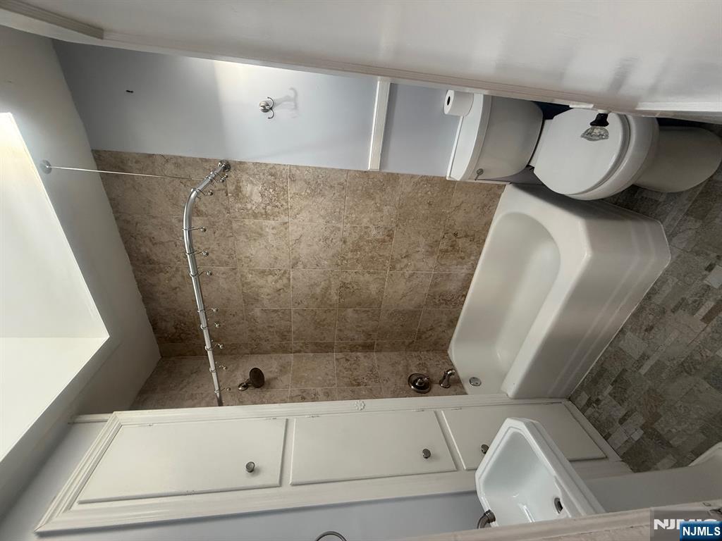 59 Union Avenue, Unit 3 North Arlington, NJ 07031 - Photo 6 of 15 a white toilet sitting next to a bath tub and a shower