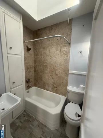 a white toilet sitting next to a bath tub