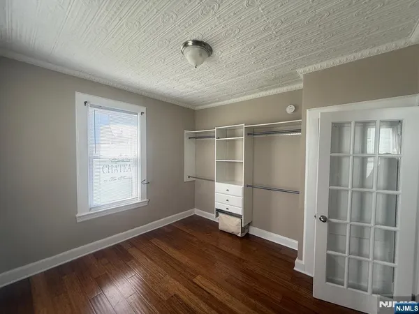 an empty room with wooden floor and window