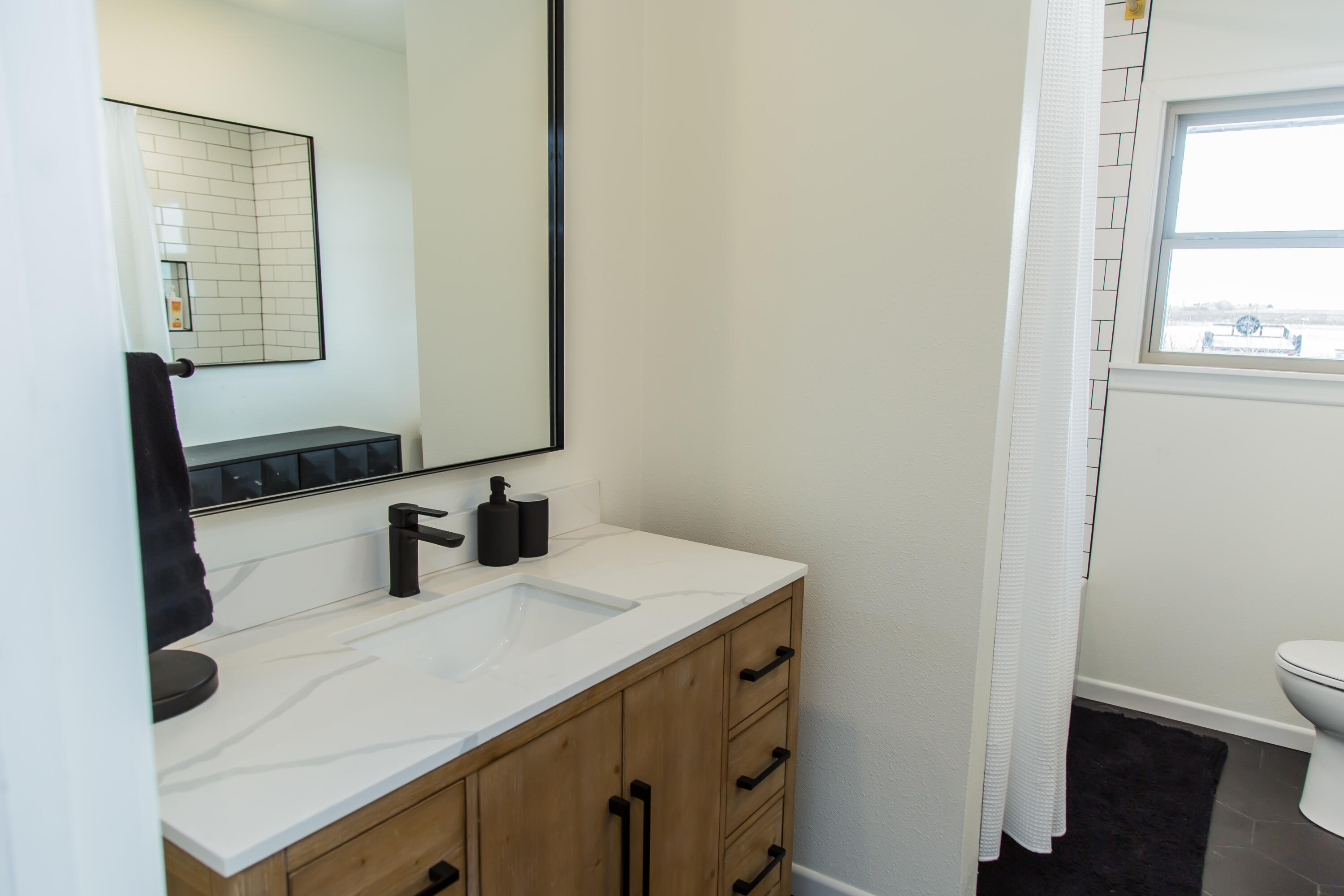 930 Sun Road Plainview, TX 79072 - Photo 15 of 22 a bathroom with a sink a toilet and mirror