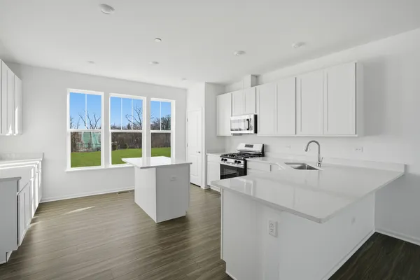 a kitchen with a sink wooden floor and white appliances