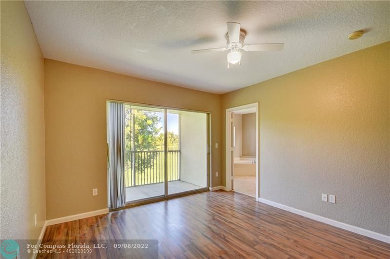 4375 Emerald Vista Lake Worth Beach, FL 33461 - Photo 15 of 27 a view of an empty room with wooden floor and a window