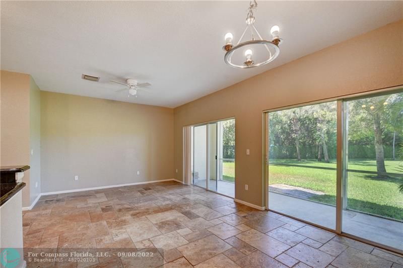 4375 Emerald Vista Lake Worth Beach, FL 33461 - Photo 8 of 27 a view of an empty room with glass door and a chandelier