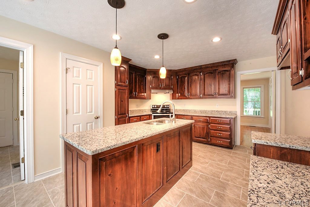 9217 Varina Road Henrico, VA 23231 - Photo 20 of 49 a kitchen with kitchen island granite countertop a sink refrigerator and cabinets
