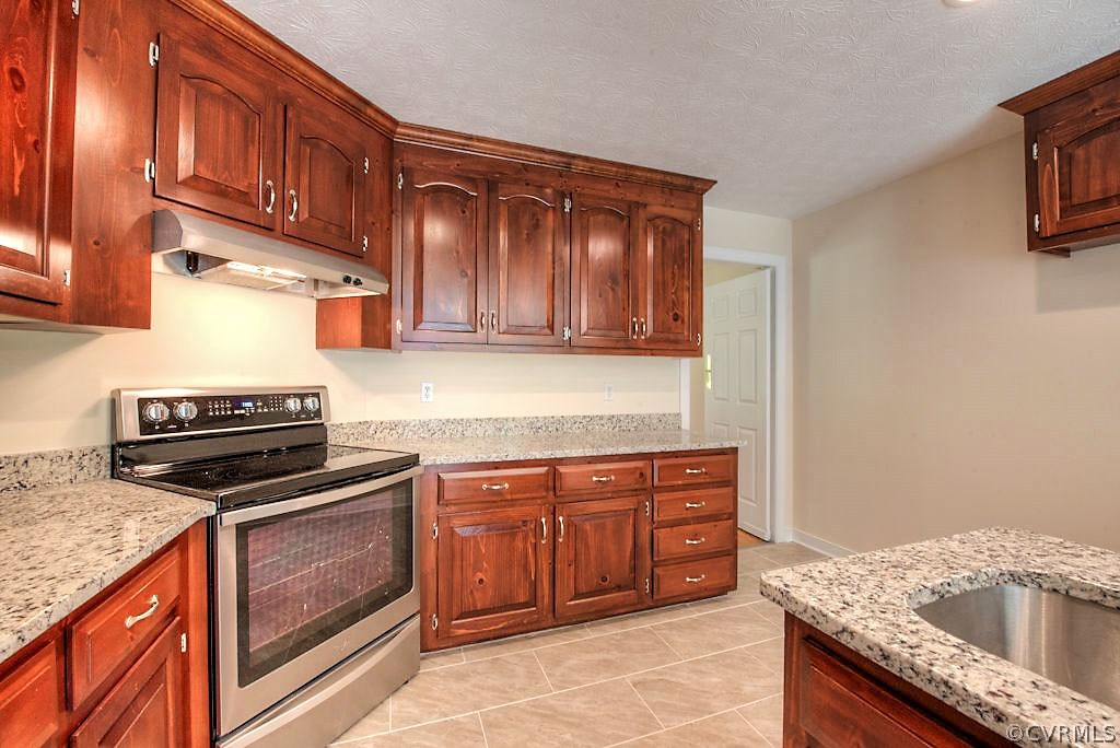9217 Varina Road Henrico, VA 23231 - Photo 22 of 49 a kitchen with granite countertop a stove sink and cabinets