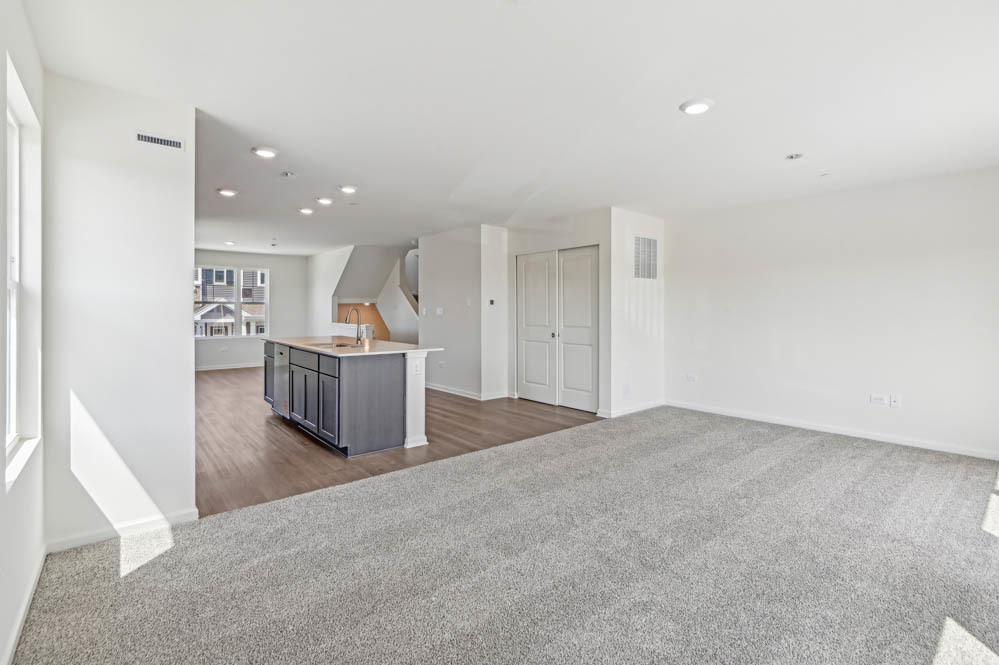 17305 Ulster Drive Tinley Park, IL 60477 - Photo 10 of 25 an empty room with wooden floor and kitchen view