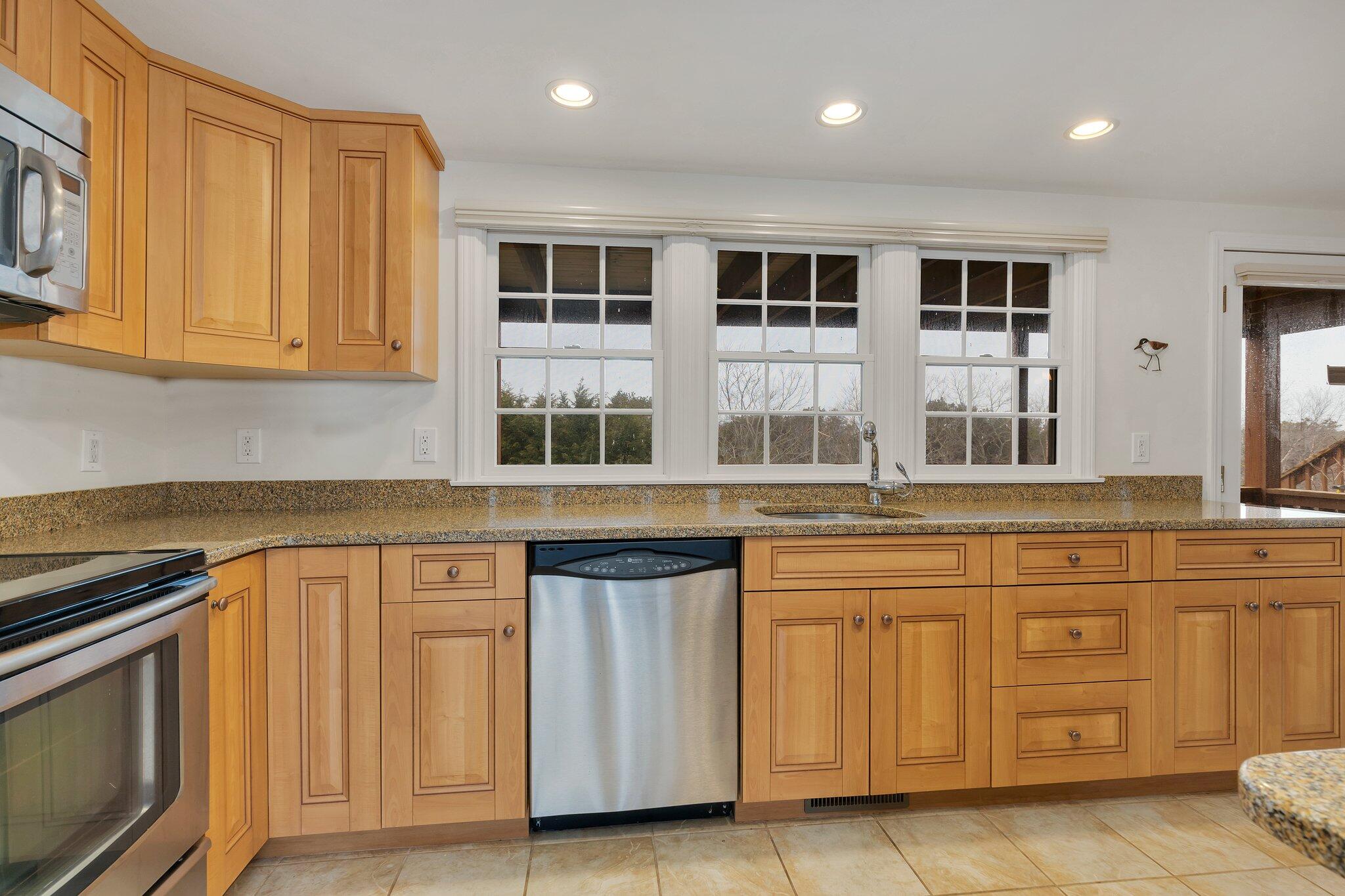 6 Shore Road, Unit 26 Truro, MA 02666 - Photo 3 of 25 a kitchen with granite countertop white cabinets and stainless steel appliances