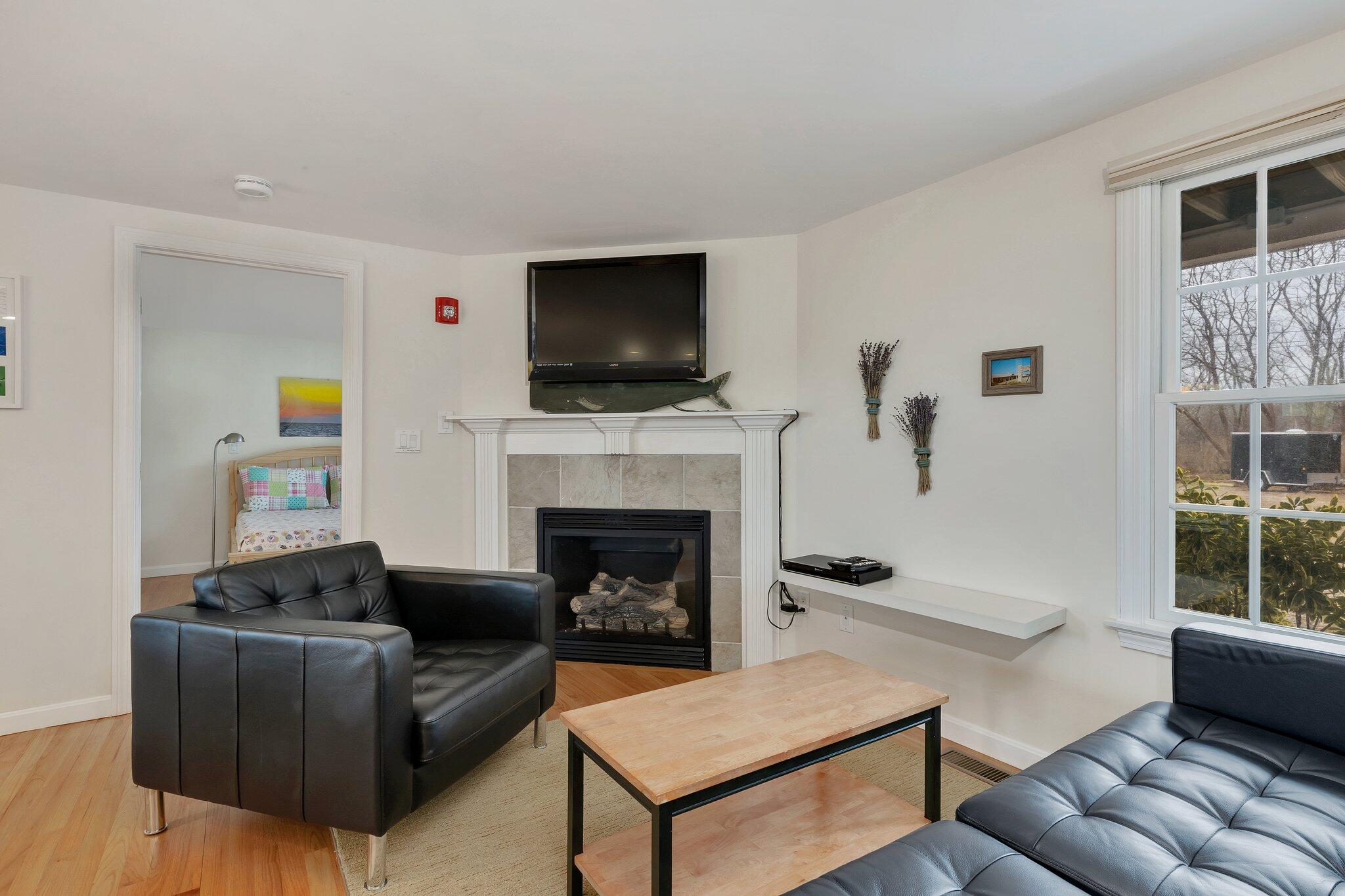 6 Shore Road, Unit 26 Truro, MA 02666 - Photo 9 of 25 a living room with furniture a flat screen tv and a fireplace