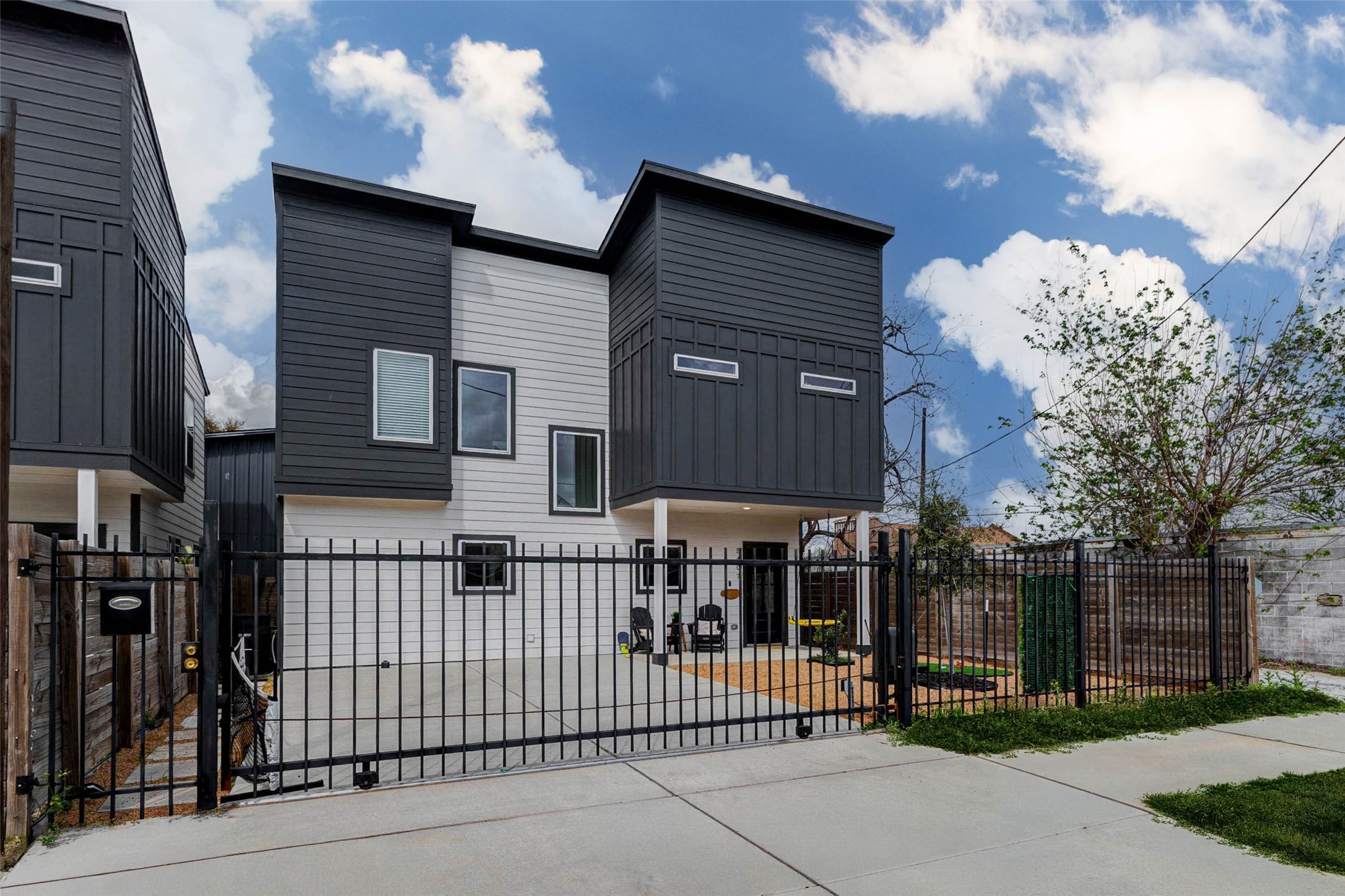 5407 Lee Street Houston, TX 77020 - Photo 15 of 17 This modern, two-story home features a sleek, contemporary design with contrasting dark and light paneling. It includes a gated driveway for added security and a small front yard space. Ideal for those seeking a stylish and secure urban living environment.