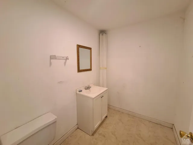 a utility room with a sink a toilet and vanity