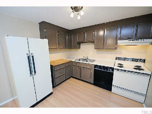 8020 Mourning Dove Road Raleigh, NC 27615 - Photo 6 of 12 a kitchen with granite countertop a refrigerator stove top oven and sink