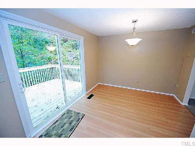 8020 Mourning Dove Road Raleigh, NC 27615 - Photo 7 of 12 a view of an empty room with wooden floor and a window