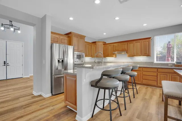 a kitchen with stainless steel appliances granite countertop a refrigerator and a stove top oven