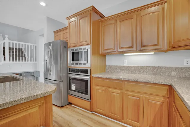 a kitchen with stainless steel appliances granite countertop a refrigerator and cabinets