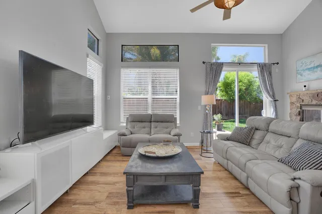 a living room with furniture a flat screen tv and a large window