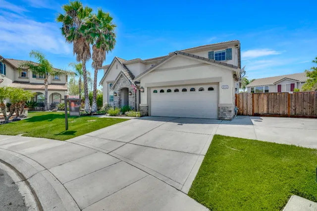 a front view of a house with a yard and potted plants