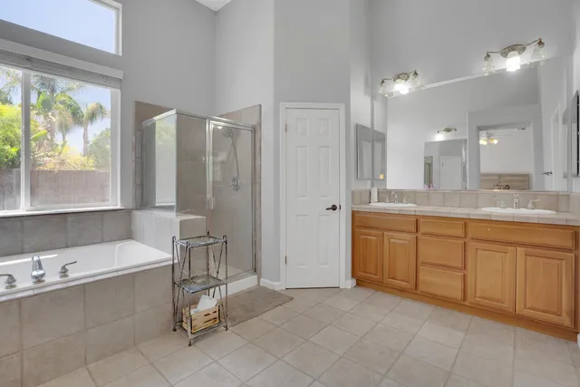 a spacious bathroom with a granite countertop sink mirror and a bathtub