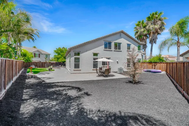 a view of a house with a yard and wooden fence