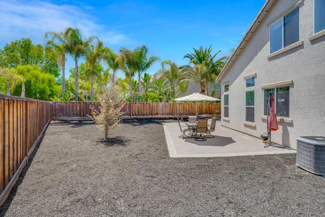 a backyard of a house with table and chairs