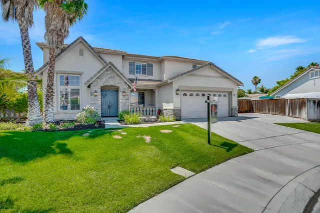 a front view of a house with a garden and yard