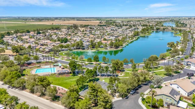 an aerial view of residential houses with outdoor space and lake view