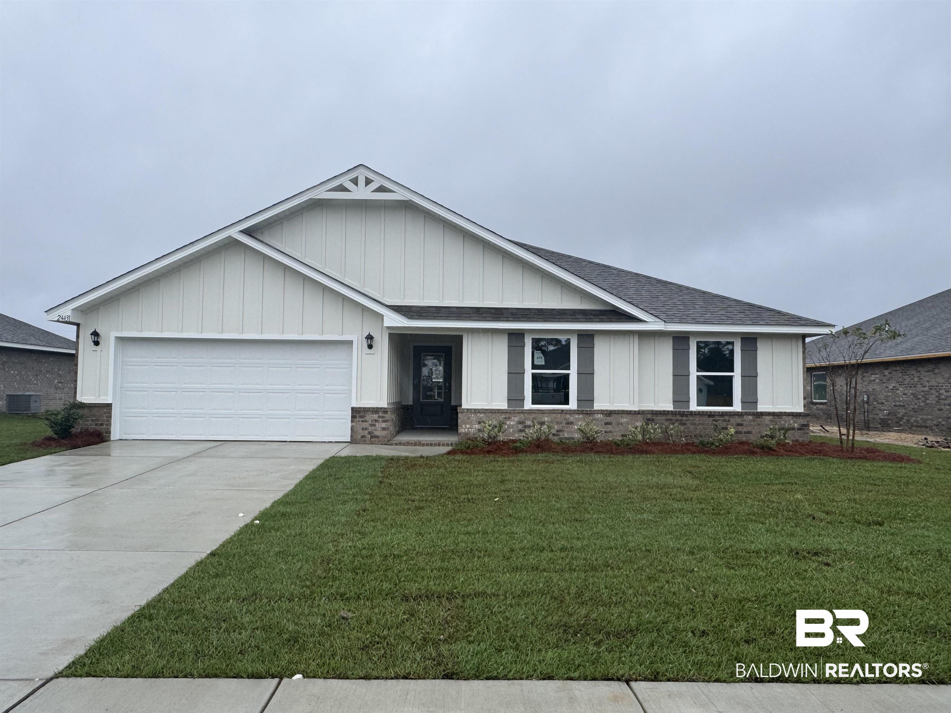 24431 Ringneck Loop Elberta, AL 36530 - Photo 1 of 15 View of front facade featuring central AC unit, a garage, and a front yard