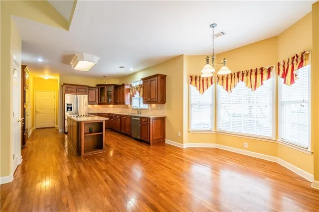 a large kitchen with a lot of counter space and a wooden floor