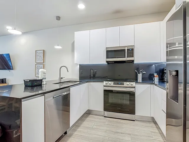 a kitchen with stainless steel appliances white cabinets and a stove